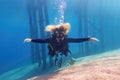 Woman scuba diver freely floating in the blue transparent water enjoing a fun Royalty Free Stock Photo