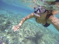 Woman scuba diving in a transparent sea