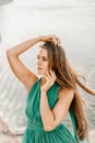 Woman sea green dress. Portrait of a happy woman with long hair in a long mint dress posing on a beach with calm sea Royalty Free Stock Photo