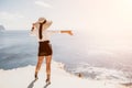 Woman sea hat. Business woman in yellow hat freelancer working over blue sea beach. Girl relieves stress from work Royalty Free Stock Photo