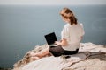 Woman sea laptop. Successful business woman working on laptop by the sea. lady typing on computer at summer day Royalty Free Stock Photo