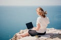 Woman sea laptop. Successful business woman working on laptop by the sea. Pretty lady typing on computer at summer day Royalty Free Stock Photo