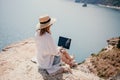 Woman sea laptop. Successful business woman working on laptop by the sea. Pretty lady typing on computer at summer day Royalty Free Stock Photo