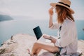 Woman sea laptop. Successful business woman working on laptop by the sea. Pretty lady typing on computer at summer day Royalty Free Stock Photo