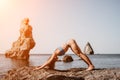 Woman sea pilates. Sporty happy middle aged woman practicing fitness on beach near sea, smiling active female training Royalty Free Stock Photo