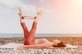 Woman sea pilates. Sporty happy middle aged woman practicing fitness on beach near sea, smiling active female training Royalty Free Stock Photo