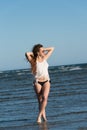Woman in sea water wear bikini, sunglasses and white shirt Royalty Free Stock Photo