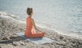 Woman sea yoga. Selective focus. Young beautiful caucasian woman in a red suit practicing yoga on the beach at sunrise