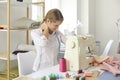 Woman tailor suffer from neck ache working on sewing machine Royalty Free Stock Photo