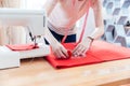 Woman seamstress working making pattern on red fabric Royalty Free Stock Photo