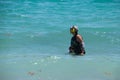 Woman using metal detector in ocean