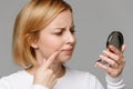 Woman searching for first wrinkles on the face, touching her cheek skin Royalty Free Stock Photo