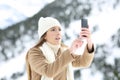 Woman searching phone coverage in winter