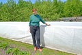 The woman on the seasonal dacha against the background of a hotbed