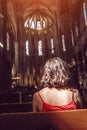 Woman seating in dark interior of a Church, Religion Concept