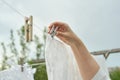 A woman securing her linens on a line with clothespins - an ode to the effectiveness and efficiency of classic laundry