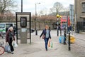 Woman seen with shopping bags walking to a city centre bus stop.