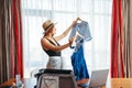 Woman selects outfits, thinking about voyage