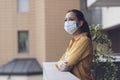 Woman relaxing on the balcony and wearing a face mask Royalty Free Stock Photo