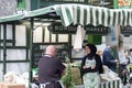 Woman is selling aprons, tea towels and other illustrated merchandise in stall at Borough Market