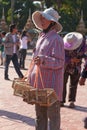 Woman selling birds for release for good luck That Luang temple Vientiane, Laos