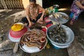 Woman selling fresh seafood including sea snakes and crabs at fresh food market Royalty Free Stock Photo