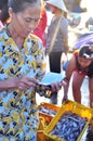 A woman is selling her fisheries in a local seafood market