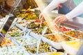 Woman selling Meze appetizers in delicatessen shop