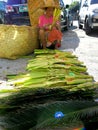 Woman selling palm and coconut leaves outside a church