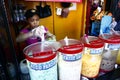 A woman sells assorted fruit juice and other refreshments during a hot summer day