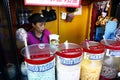 A woman sells assorted fruit juice and other refreshments during a hot summer day