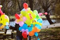 Woman sells colorful balloons in the park. tinted image