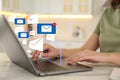 Woman sending emails at table in kitchen