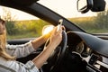 Woman sending messages with smartphone while driving automobile. Female driver using mobile phone on the road during Royalty Free Stock Photo