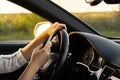 Woman sending messages with smartphone while driving automobile. Female driver using mobile phone on the road during Royalty Free Stock Photo