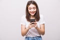 Young woman sending a sms on cell phone, isolated on white background Royalty Free Stock Photo