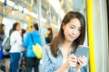 Woman sending sms on cellphone in train Royalty Free Stock Photo