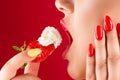 Woman with sensual lips eats strawberries with cream Royalty Free Stock Photo