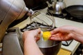 Woman separates egg whites from yolk in mixer bowl.