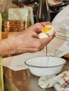 Woman separates the white from the yolk in an egg in her home kitchen