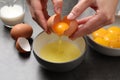 Woman separating egg yolk from white over bowl at grey table, closeup Royalty Free Stock Photo