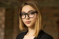 Woman serious. Closeup portrait business girl looking confident at you camera in black suit formal wear with eye glasses outside Royalty Free Stock Photo