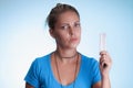 Woman with serious expression showing a blister medication. Birth control pill. Wearing blue shirt over blue background Royalty Free Stock Photo