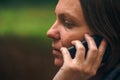 Woman with serious face expression talking on phone in park Royalty Free Stock Photo