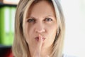 Woman with serious face holds her finger on her lips and asks for silence. Royalty Free Stock Photo