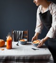 Woman serve breakfast table on grey