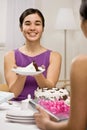 Woman serving birthday cake at party