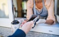 Woman serving coffee through window, contactless payment and back to normal concept. Royalty Free Stock Photo