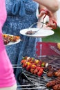 Woman serving dinner on barbecue party Royalty Free Stock Photo
