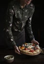 Woman serving homemade pizza on the table